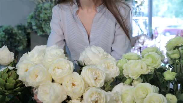 Mãos femininas move rosas brancas na loja de flores — Vídeo de Stock