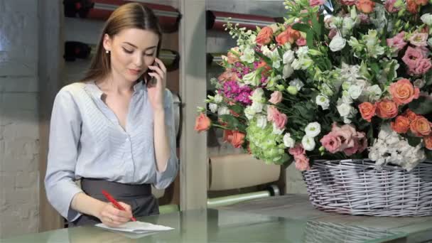 Θηλυκό Ανθοπωλείο δέχεται διαταγής μπουκέτο λουλούδια στο ανθοπωλείο — Αρχείο Βίντεο