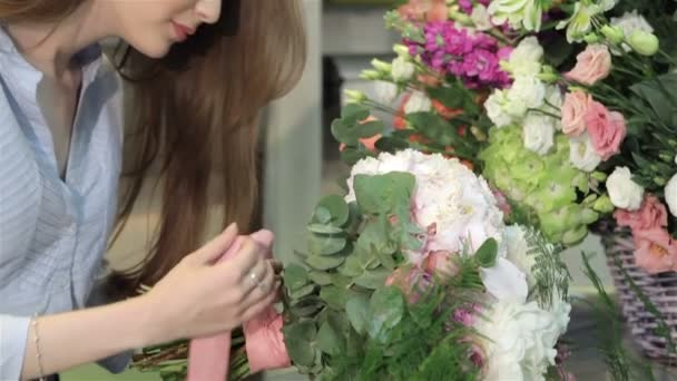 Kvinnliga florist gör en bukett blommor på blomsteraffär — Stockvideo