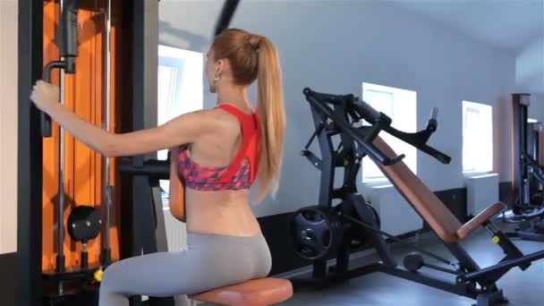 Vrouw zit terug op de Bank van sportschool machine in het fitnesscentrum — Stockvideo