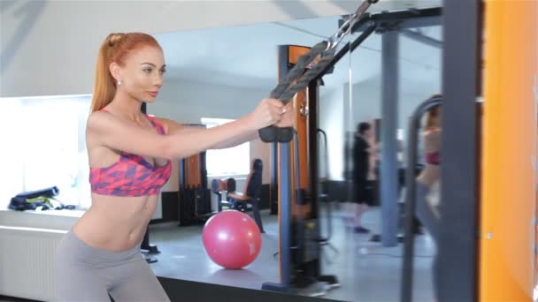 Femme tirant la corde de la machine de gymnastique à ses cuisses au centre de fitness — Video