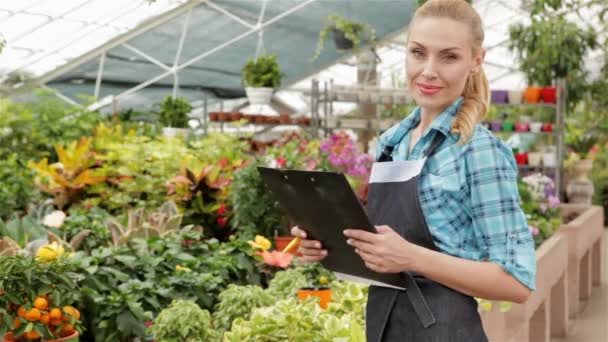 Kvinnliga florist har svarta tavlan i trädgård centrum — Stockvideo