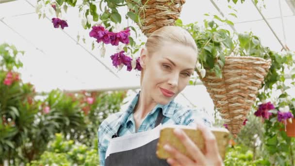 Női virágüzlet teszi selfie a kert közepén — Stock videók