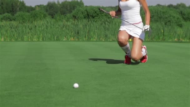 Женщина стоит на коленях перед гольфом — стоковое видео