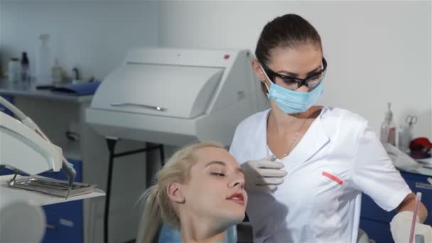 Zahnärztin benutzt zahnärztliches Werkzeug, um Zähne von Patienten zu überprüfen