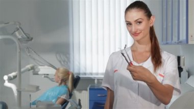 Diş hekimi diş hekimi kabine onun araçları gösterir