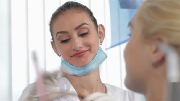 Dentista femenina lleva gafas protectoras en el gabinete del dentista — Vídeos de Stock