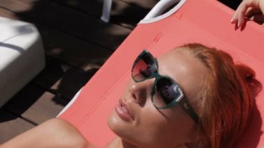 Woman lying in the sun near the swimming pool