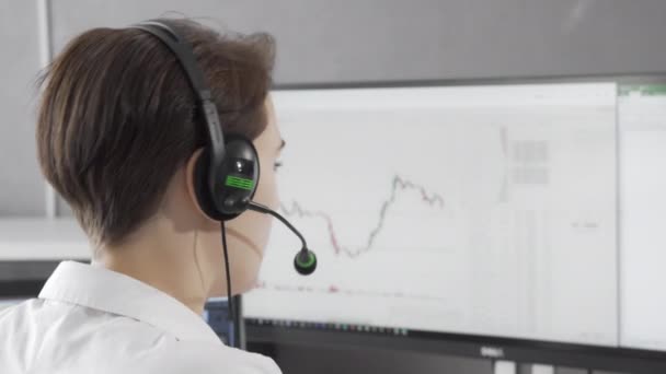 Visão traseira tiro de um agente de call center feminino usando fone de ouvido enquanto trabalhava — Vídeo de Stock