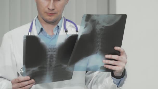 Καλλιεργημένη φωτογραφία γιατρού που εξετάζει ακτινογραφίες ασθενούς — Αρχείο Βίντεο