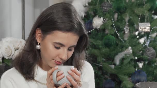 自宅でお茶を飲みながらカメラに笑顔の美しい幸せな女性 — ストック動画