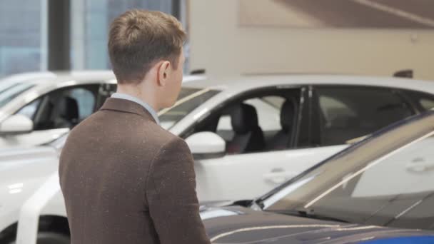 Radosny dojrzały mężczyzna uśmiecha się do kamery trzymając kluczyki od samochodu w salonie — Wideo stockowe