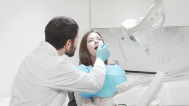 Profesyonel dişçi tarafından dişçi muayenesi yapılan bir kadın hasta.