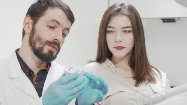 Jovem mulher bonita conversando com seu dentista após o check-up dentes — Vídeo de Stock