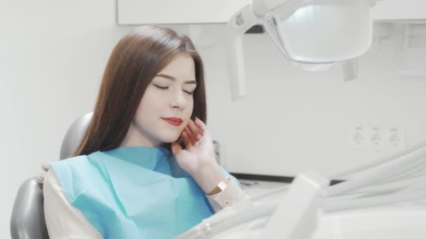 Νεαρή γυναίκα που πάσχει από πονόδοντο κάθεται στην οδοντιατρική καρέκλα — Αρχείο Βίντεο