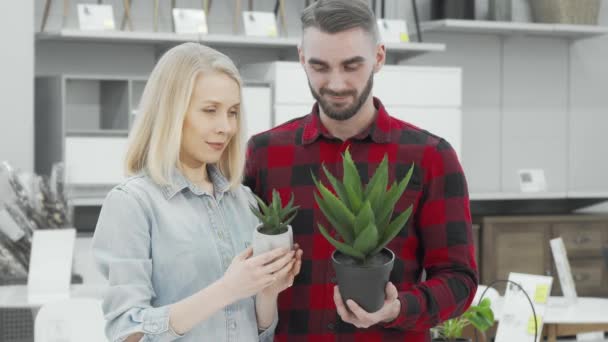 Giovani coppie che acquistano piante in vaso nel negozio di arredamento — Video Stock