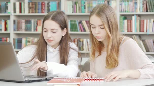 Nastolatki cieszą się razem studiami w bibliotece — Wideo stockowe