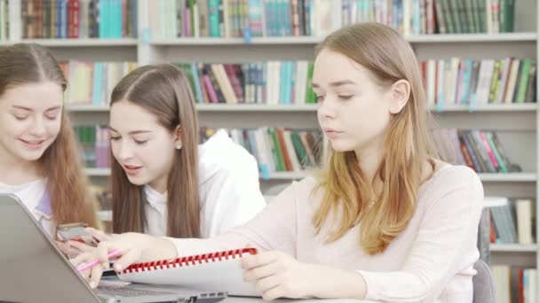 Teen schoolgirl working on an assignment at the library — Stock Video