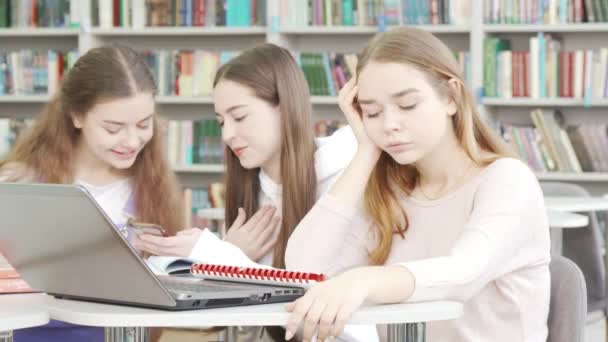 Adolescente buscando cansado y aburrido mientras estudia en la biblioteca — Vídeos de Stock