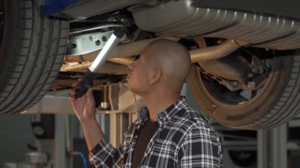 Joven africano examinando su automóvil en el taller — Vídeos de Stock