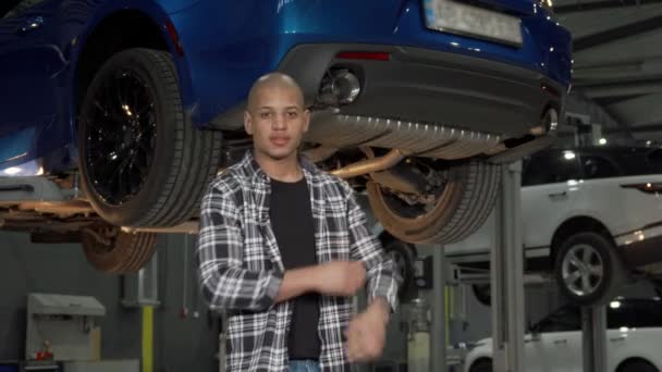 Bonito reparador de carro feliz sorrindo para a câmera em sua garagem — Vídeo de Stock