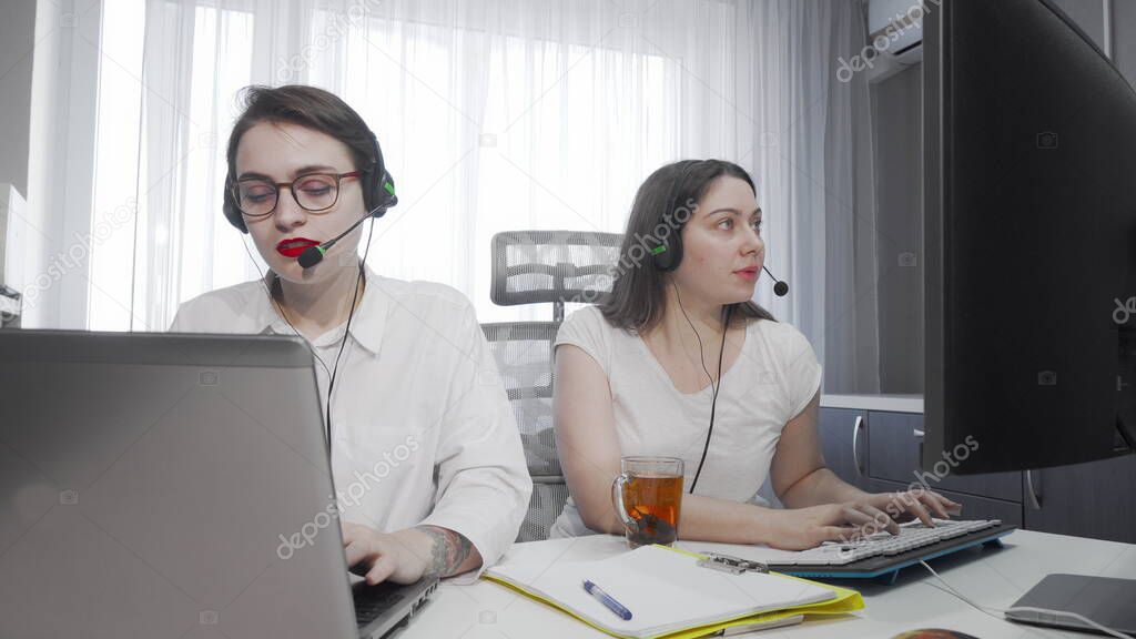 Two female call center agents working on their computers