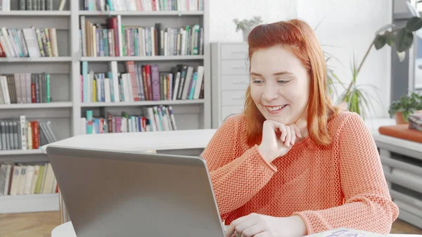 Wanita muda ceria menonton film lucu di laptopnya Stok Foto Bebas Royalti