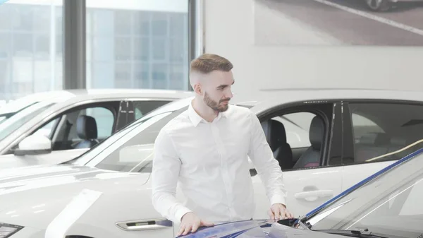 Empresário atraente examinando automóveis à venda no salão de concessionárias — Fotografia de Stock
