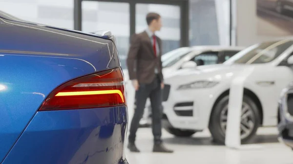 Onherkenbare man onderzoekt auto 's te koop bij de dealer Stockfoto