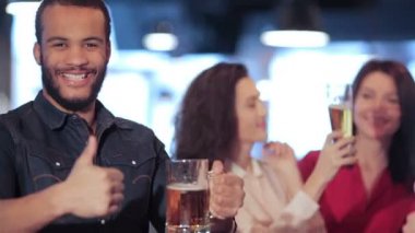 Afrikalı Çocuk gösteren başparmak iki güzel kız arka plan üzerinde gülümseyen