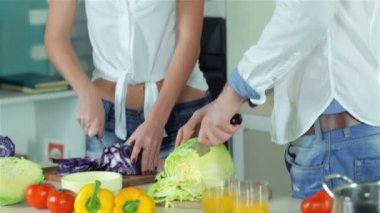 Bir seven çift dilimlenmiş sebze ve doğrudan kameraya gülümseyen