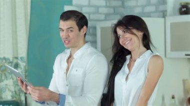 Adam kız arkadaşı yemek tarifleri sebze güveç için tablet üzerinde gösterir.