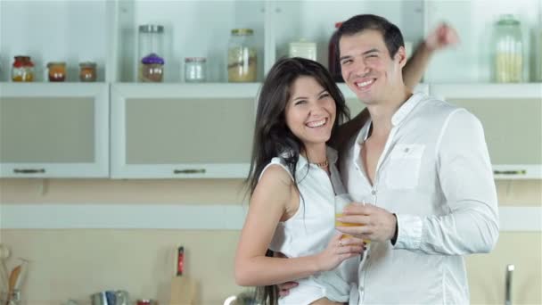 Pareja de pie en la mesa de la cocina con verduras sonriendo directamente a la cámara y ella pulgares hacia arriba — Vídeo de stock