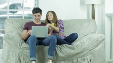 Kanepede oturan ve çay içen neşeli gençler