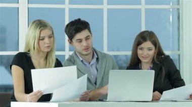Gülümseyen işadamı masada oturan ve bir dizüstü bilgisayara bir iş planı yazarak