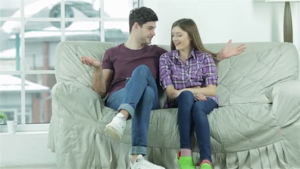 El tipo lanza sus manos, sentado con su novia — Vídeos de Stock