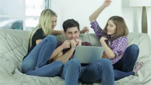 Girls memeluk seorang pria di sofa — Stok Video