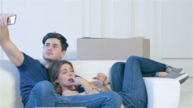 Bir kız ve taşıma ve telefon kameraya gülümseyen bir adam