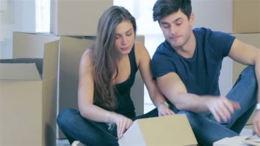 Couple in love moving and looking inside box