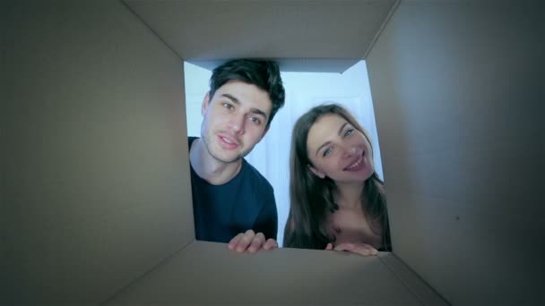 Smiling man and woman in love look into boxes — Stock Video