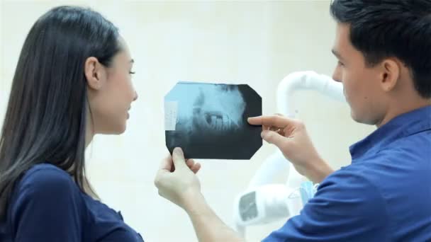 Diş hekimi diş diş ofiste bir hasta röntgen gösterir — Stok video