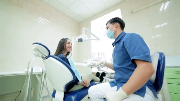 O dentista da máscara diz ao paciente, depois mostram um polegar até à câmara. — Vídeo de Stock