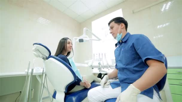 Zubař hovoří k pacientovi, pak otočit společně a ukazují palce na kameru — Stock video