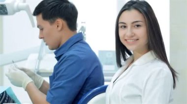 Kız-Yardımcısı gülümseyen ve başparmak üzerinde arka plan diş hekimi