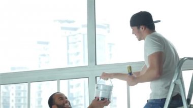 Bir adam başka bir adamla merdivenin boya alır