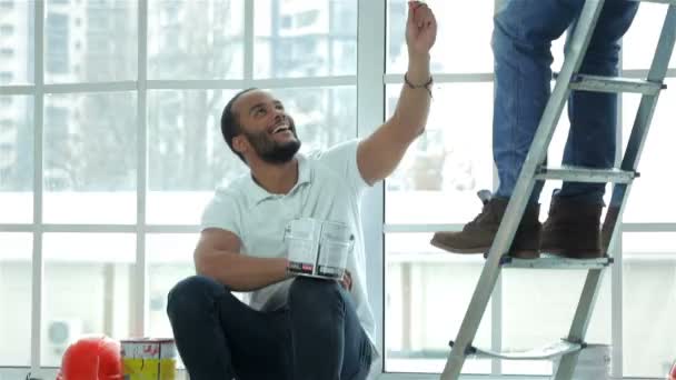 Young painter man sitting on a window — Stock Video