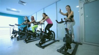 Simülatör üzerinde pedal kız spor ve başparmak sırıtmak