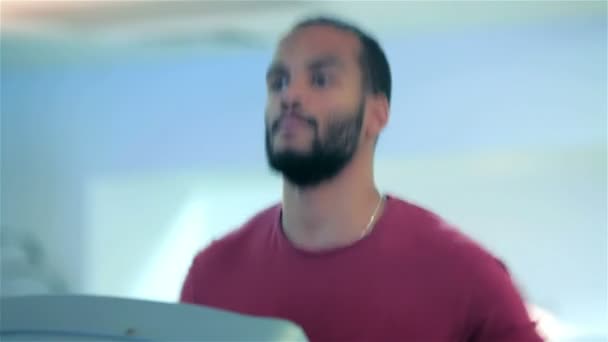 Sport man running on a treadmill in the gym smiling and looking at the camera — Stock Video