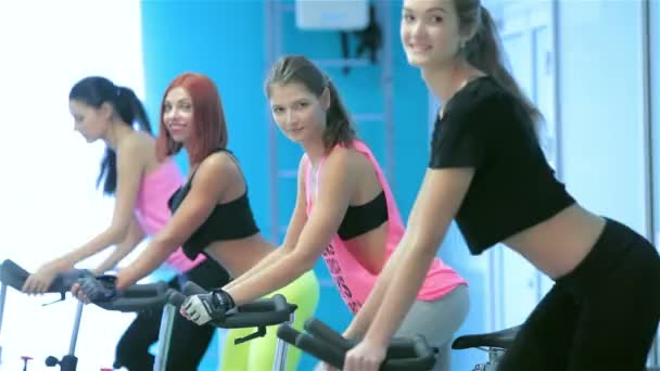 Sierlijke sexy meisje trappen en kijken naar de camera op een upright bike — Stockvideo