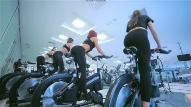 Bir grup kız kadın sporcuların sabit bir bisiklet üzerinde